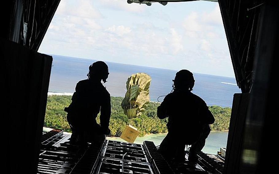 Airmen from Yokota Air Base, Japan, deliver boxes of humanitarian aid to the Yap Islands during Operation Christmas Drop on Tuesday. More than $93,000 in goods will be dropped over various Micronesian Islands throughout the week.