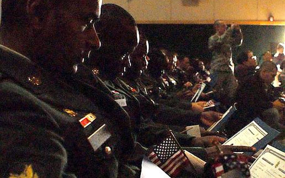 Soldiers look at their new citizen certificates during a naturalization ceremony at Yongsan Garrison, South Korea on Wednesday. Thirty-eight soldiers joined 11 spouses and 2 children in becoming U.S. citizens.