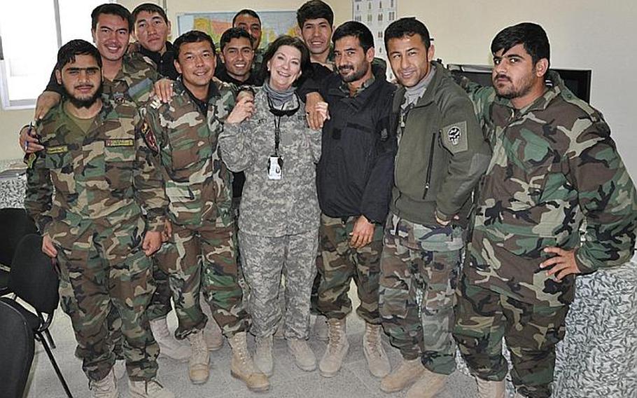 Judy Ryan, a teacher from the Fort Knox Community Schools in Kentucky, poses with Afghan security forces personnel she teaches English to in Afghanistan.