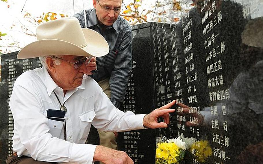 Durl Gibbs, left, places his finger next to the name of Japanese army Sgt. Keijiro Hojo. Gibbs and his son Wes both flew from Montana to return a wallet that Durl Gibbs took from Hojo's body while fighting on Okinawa during World War II. The wallet contained many photos as well as hair and fingernail clippings.
