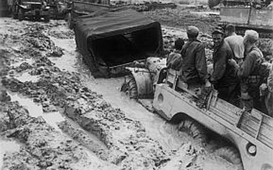 Vehicles mired in mud following the heavy rains of late May 1945 on Okinawa. The conditions made the movement of ammunition and rations forward and the evacuation of casualties to the rear very difficult.