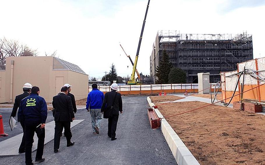 A reporter and government of Japan officials tour the grounds for what will be new facilities set aside for Japanese Self Defense Forces at Yokota Air Base, Japan.