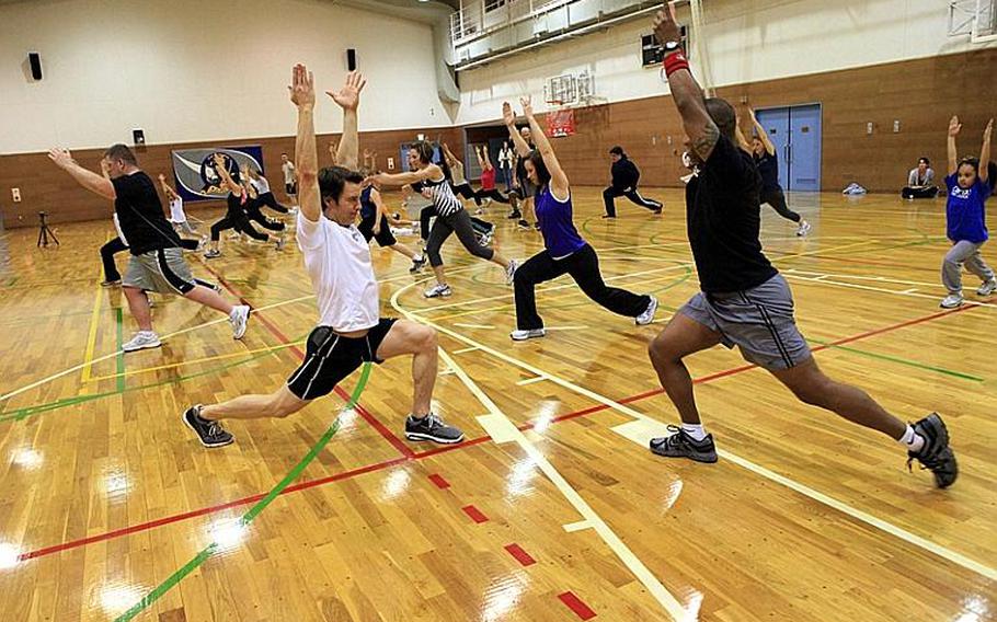 Fitness guru Tony Horton, left foreground, a developer and star of the 'P90X' home fitness program, leads military personnel and families in exercises Wednesday at Yokota Air Base as part of his weeklong tour of military bases in the Pacific.