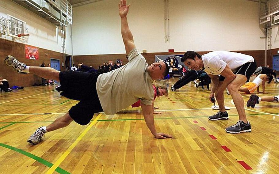 Fitness guru Tony Horton, right, a developer and star of the 'P90X' home fitness program, leads military personnel and families in exercises Wednesday at Yokota Air Base. Horton is on a weeklong tour of military bases in the Pacific.