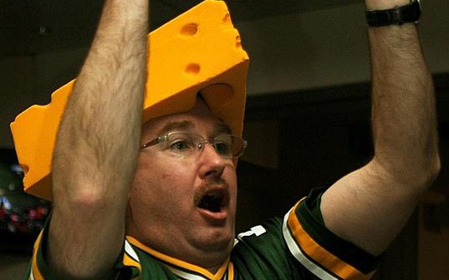 Sporting a Cheesehead, Naval Air Facility Atsugi civilian Randy Jacobson cheers on a Green Bay Packers touchdown during Monday's Camp Zama Community Club's Super Bowl party.