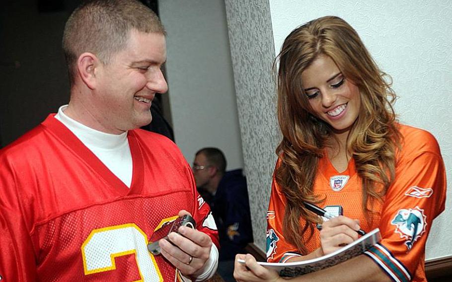 Miami Dolphins cheerleader Bekah Stevens obliges Army Maj. Richard Wellman with an autograph during Monday's Camp Zama Community Club's Super Bowl party. Stevens' father, Edward Jr., is a retired Army doctor who was born in Japan; his father, Edward Sr., was an Army judge at Camp Zama in the 1950s.