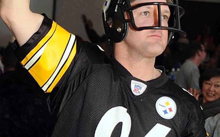 Sporting a Hines Ward jersey and replica helmet, Camp Zama civilian Stefan Thompson waves his Terrible Towel during Monday's Camp Zama Community Club's Super Bowl party.