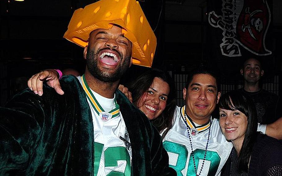 (Left to right) Air Force Tech. Sgt. Richard Stowe Jr., his wife Amalia Stowe, Air Force Staff Sgt. Jonathan Torres and his wife Amber Torres, celebrate after the final whistle of the Super Bowl at the Rocker Non-Commissioned Officers Club on Kadena Air Base. More than 460 people packed into the club to watch the game.