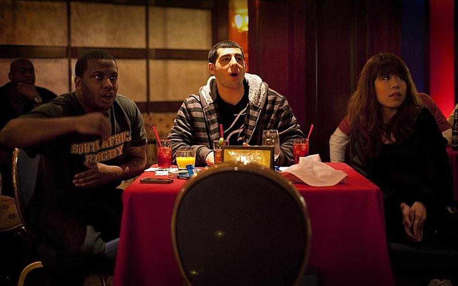 Green Bay Packers fans Petty Officers Tim Lee (left) and Andrew Matyas from Naval Air Facility Atsugi's Strike Fighter Squadron-27 along with Miwa Kawameura take in the Packers Super Bowl XLV victory at the New Sanno Hotel in Tokyo on Monday.
