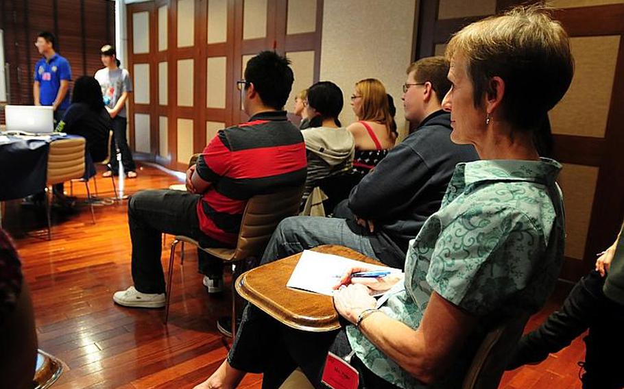 Jackie Pope, a Mathematics teacher from Kubasaki High School in Okinawa, grades students on their final presentations Thursday at MathematicaFest 2011 in Onna Village, Okinawa.