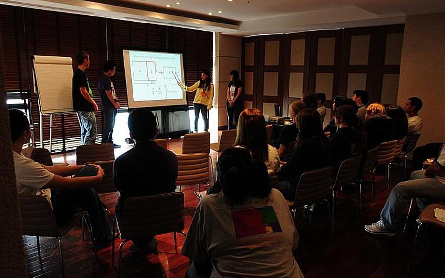 From left to right, Tyler Stanley from Guam High School, Andrew Baac from Zama High School, Rachel Poluhowich from E.J. King High School and Daye Kim from Seoul American High School give their final presentation to fellow students and teachers at the culmination of MathematicaFest 2011 in Onna Village, Okinawa. This was the second year of the conference. Fifty-seven students from all 12 DODEA high schools from around the Pacific attended.