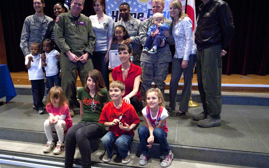 Recipients of the Home Front Hero award stand with their families and Col. Otto Feather, right, 374th Airlift Wing commander, during an award ceremony recognizing the children for their outstanding conduct and sacrifices made while their parents were on deployment. The ceremony was held Feb. 11, 2011, at the Yokota Airman and Family Readiness Center.