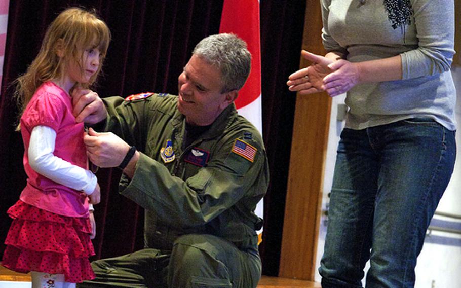 Capt. Chuck Elder presents his 5-year-old daughter Kira with the Home Front Hero award Feb. 11, 2011, at the Yokota Airman and Family Readiness Center. The award was for her outstanding behavior and sacrifices made during his recent deployment.