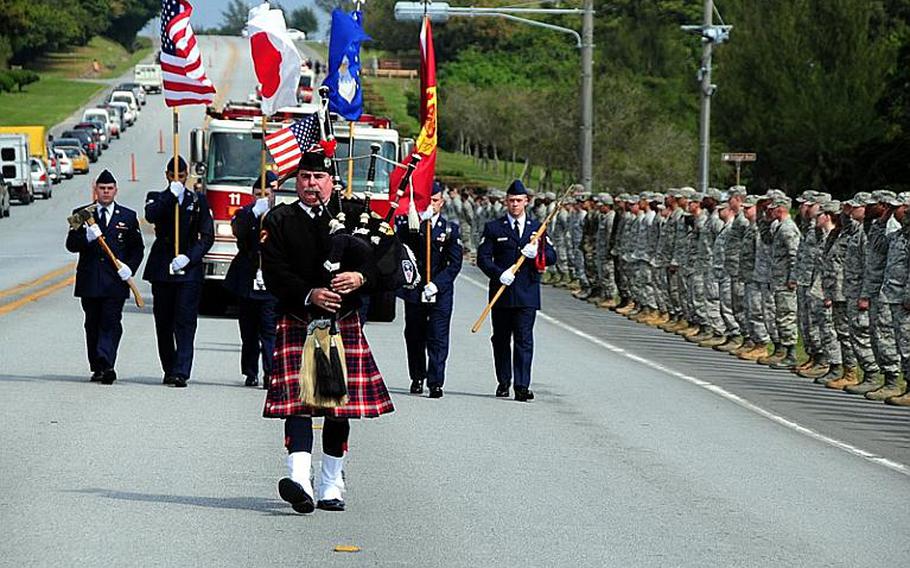 A bagpiper and military color guard lead a procession down Douglas Blvd. on Kadena Air Base, Okinawa, in a ceremony Wednesday to remember Airman 1st Class Derek Kozorosky, who was killed on base Friday evening in a vehicle accident.