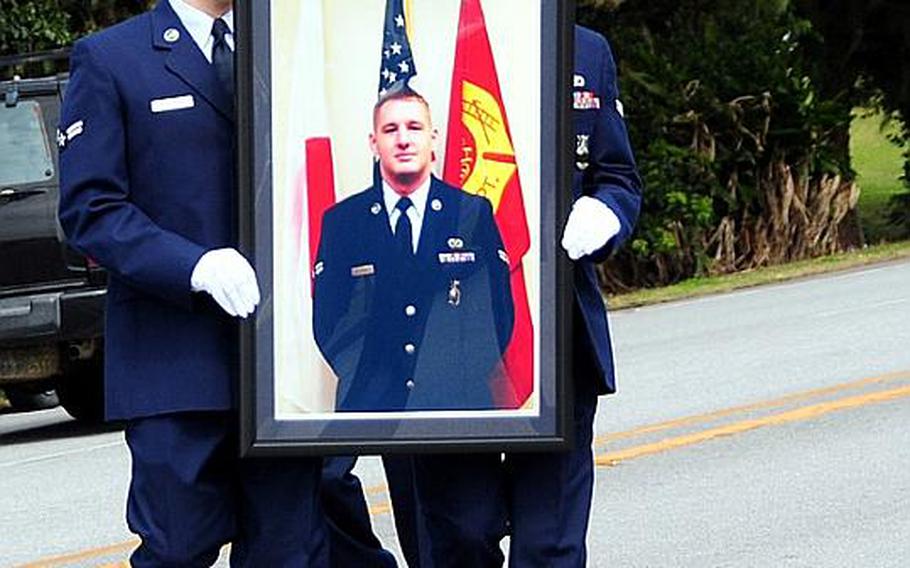 Airmen carry a picture of Airman 1st Class Derek Kozorosky during a memorial procession Wednesday along Douglas Blvd. on Kadena Air Base, Okinawa. Kozorosky was on duty when he was killed in a training accident on Friday.