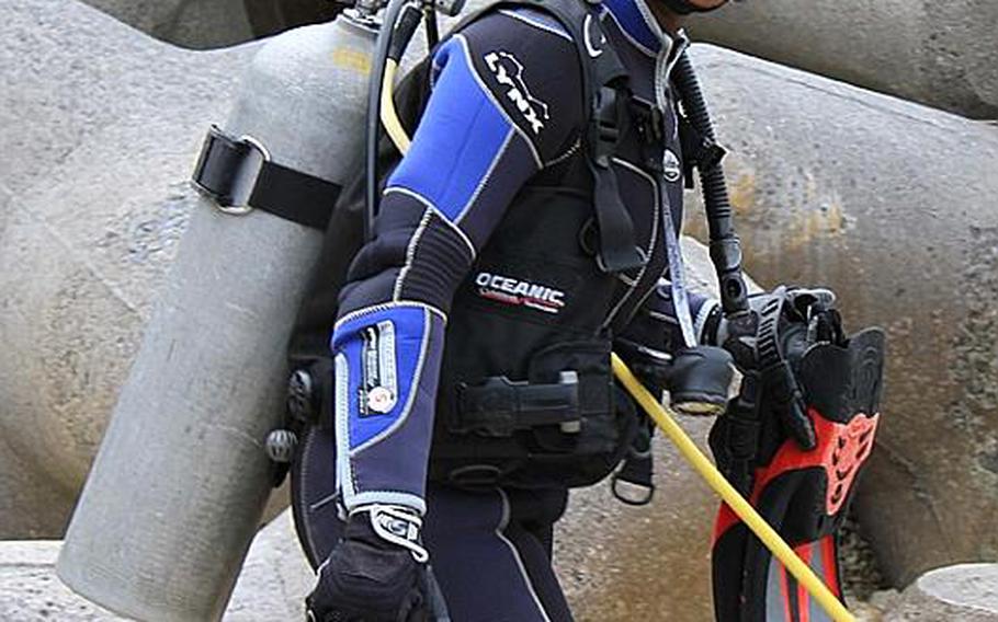 Okinawa-based Army Sgt. Juanita Tompkins, a paralegal specialist with Staff Judge Advocate, 10th Support Group, re-enlisted Wednesday 30 feet underwater.