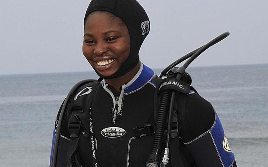 Okinawa-based Army Sgt. Juanita Tompkins, a paralegal specialist with Staff Judge Advocate, 10th Support Group, re-enlisted 30 feet of underwater Wednesday.