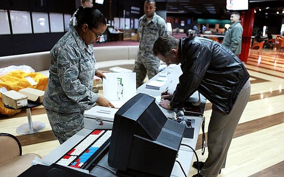 Dean Bias, right, a civilian contractor at Yokota, sends off his package using the alternate post office site set up at Yujo Community Center. The postal workers at Yokota set up the alternate postal site to test out their Contingency Kit.