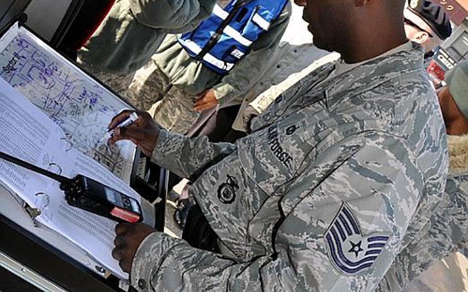 Tech. Sgt. George Gooden, of the 35th Security Forces Squadron on Misawa Air Base, Japan, charts the flow of traffic though the 'entry control point' of a simulated aircraft fire at the Misawa City port on Wednesday. Japanese and American officials hosted the joint training exercise to fine-tune their response to an off-base incident involving an American aircraft.