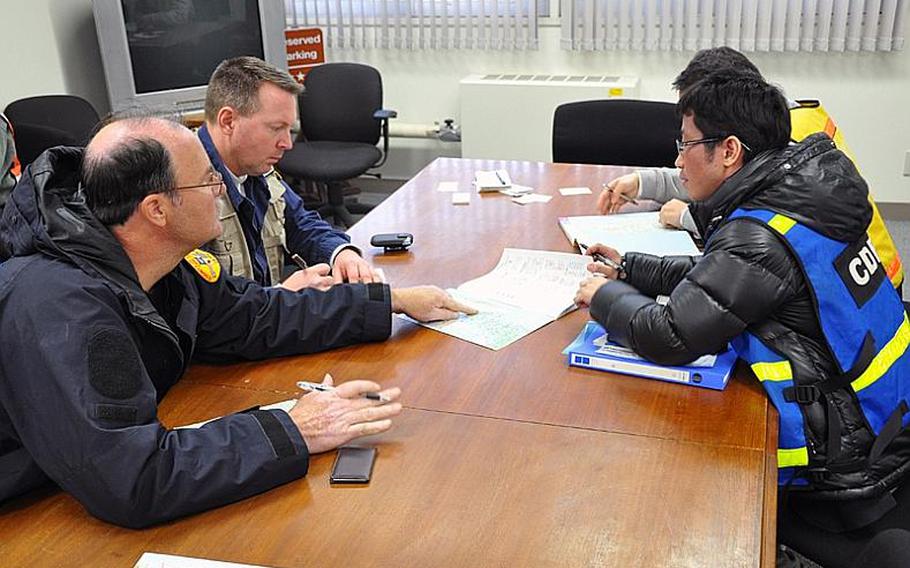 U.S. rescue team leaders Pat Rohaley, left, and Bob Zoldos discuss planned rescue efforts in the fishing village of Ofunato with Japanese government officials Sunday afternoon at Misawa Air Base, Japan.
