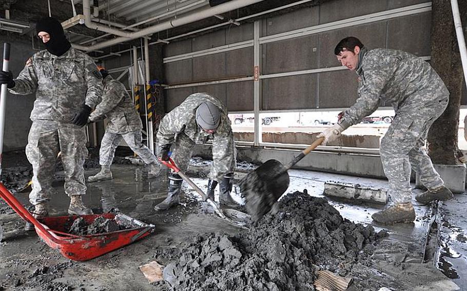 U.S. Army and Air Force volunteers from Misawa Air Base, Japan, dig sludge out of Hachinohe city fishing port on Thursday.