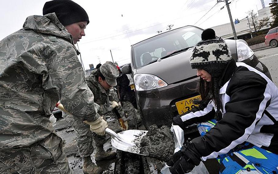 Volunteers from Misawa Air Base, Japan, dig sludge out of Hachinohe city fishing port on Thursday. Hundreds of volunteers were in the port as part of Operation Tomodachi, a U.S. Forces Japan initiative to provide humanitarian relief efforts to local communities following the March 11 earthquake and  tsunamis.