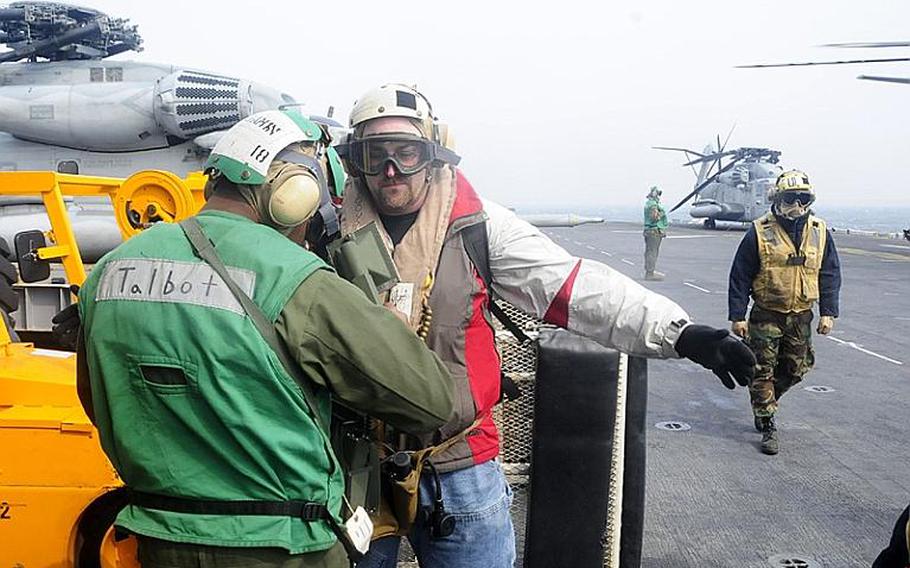 Richard Teets, a member of a U.S. Navy radiological assistance team, undergoes a radiological scan after arriving on the flight deck of the amphibious assault ship USS Essex. The 21-member team arrived last weekend and will check for radiation on personnel and aircraft who travel in areas affected by radiation from the Fukushima Daiichi plant.