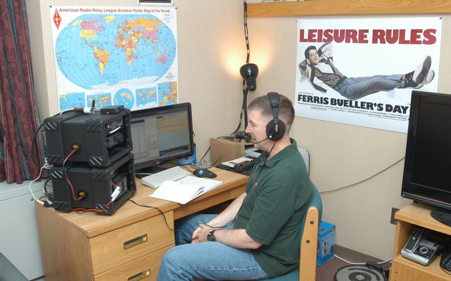 U.S. Army Maj. Scott Hedberg talks on the ham radio he has set up in his barracks room at Camp Red Cloud in South Korea.