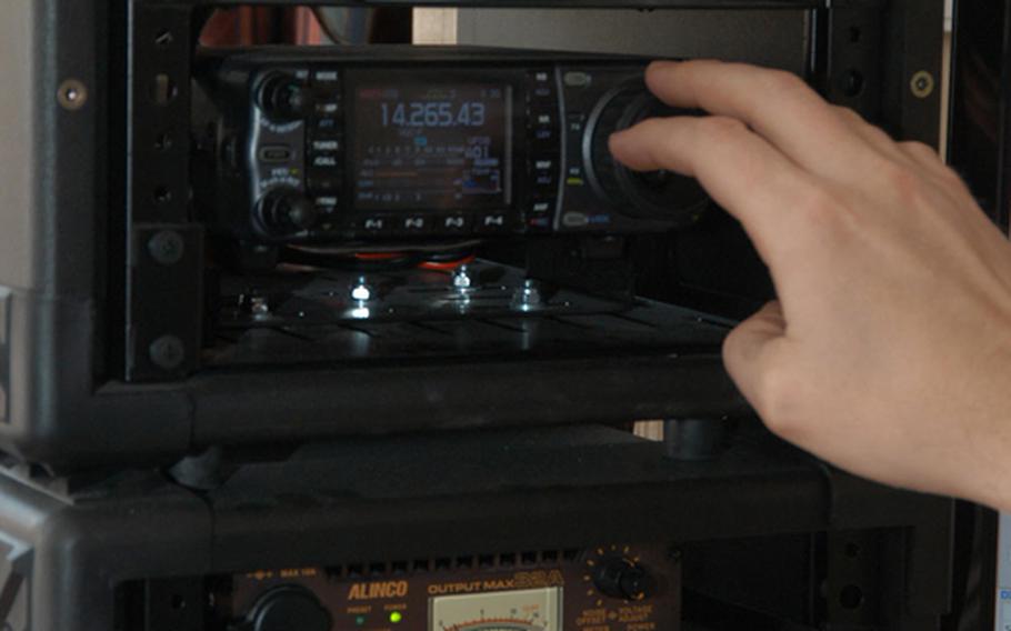 U.S. Army Maj. Scott Hedberg checks different frequences as he searches for potential ham radio contacts in other countries from his barracks room at Camp Red Cloud in South Korea.