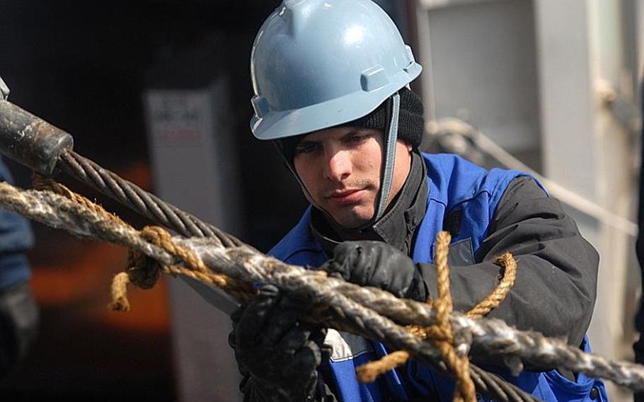 Seaman Ryan Zevinsky, from Gloucester, Va., removes a line from a span wire aboard the Ticonderoga-class guided-missile cruiser USS Shiloh during a replenishment-at-sea with the Military Sealift Command Dry Cargo and Ammunition ship USNS Matthew Perry on Tuesday. Shiloh is currently off the northeastern coast of Japan conducting humanitarian assistance operations as part of Operation Tomodachi.