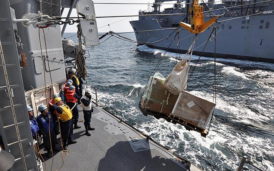 Sailors aboard the Ticonderoga-class guided-missile cruiser USS Shiloh receive cargo from the Military Sealift Command Dry Cargo and Ammunition ship USNS Matthew Perry during a replenishment-at-sea Tuesday.