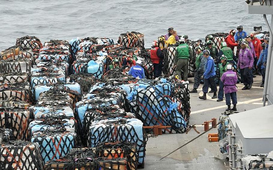 Sailors arrange pallets on the main deck aboard 7th Fleet command ship USS Blue Ridge during a vertical replenishment-at-sea with the USNS Pecos Monday. Blue Ridge transferred pallets of humanitarian assistance and disaster relief supplies to support Operation Tomodachi relief efforts in Japan.