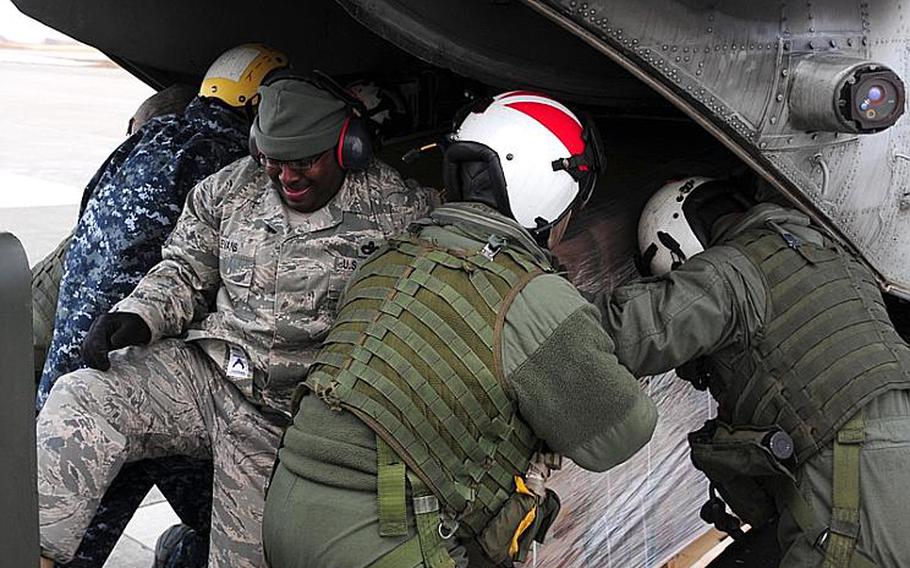 Servicemembers load humanitarian assistance and disaster relief supplies onto a CH-46E Sea Knight helicopter assigned to Marine Medium Helicopter Squadron 262 on Tuesday.