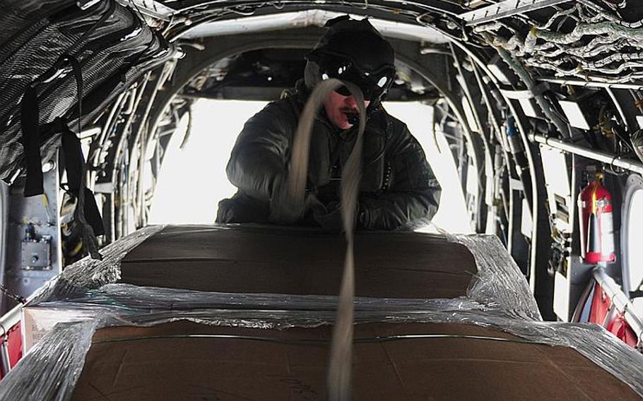 Gunnery Sgt. Sam Carnes secures humanitarian assistance and disaster relief supplies inside a CH-46E Sea Knight helicopter assigned to Marine Medium Helicopter Squadron 262.