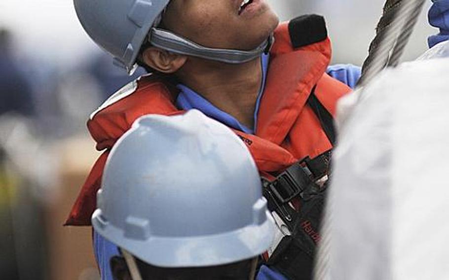 Seaman Nicholas Constable works a cargo-handling line during a vertical replenishment-at-sea aboard 7th Fleet command ship USS Blue Ridge Monday. The Blue Ridge transferred pallets of humanitarian assistance and disaster relief supplies to support Operation Tomodachi relief efforts in Japan.