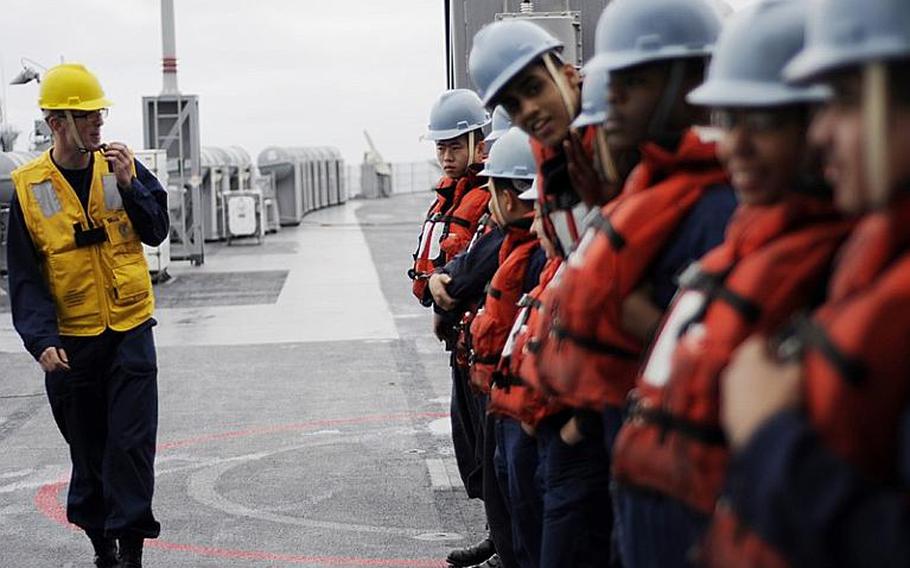 Petty Officer 2nd Class Andrew Raum briefs line handlers before a replenishment-at-sea aboard 7th Fleet command ship USS Blue Ridge on Monday. Blue Ridge transferred pallets of humanitarian assistance and disaster relief supplies to support Operation Tomodachi relief efforts in Japan.