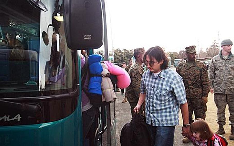 Families from Camp Zama board buses going to the passenger terminal Friday at the Taiyo Community Center on Yokota Air Base. 