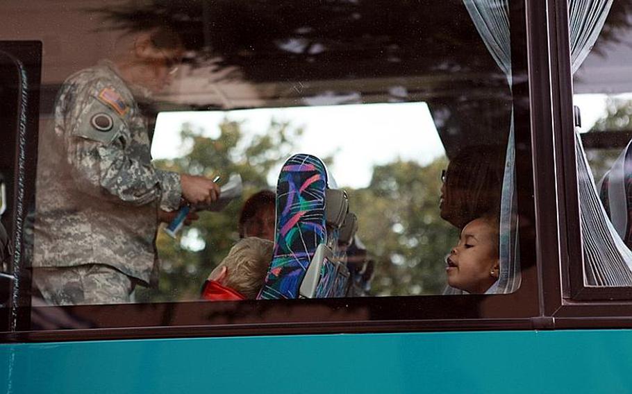 Camp Zama families await their bus ride to the passenger terminal Friday on Yokota Air Base. Thousands of U.S. family members have been flown out of Japan as concerns grow over the ongoing nuclear crisis.