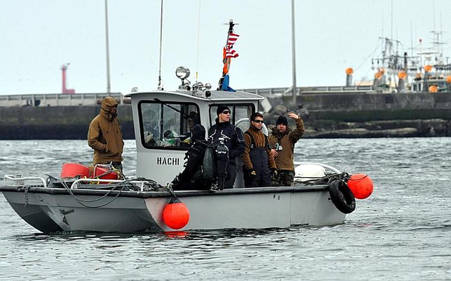 U.S. Navy divers work in the Hachinohe City port on Friday, about 45 minutes south of Misawa Air Base, Japan. Japanese officials have asked the U.S. military for help in opening the port, which will allow barges to once-again deliver fuel.