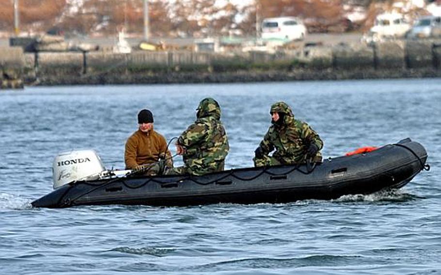 U.S. Navy divers work in the Hachinohe City port on Friday, about 45 minutes south of Misawa Air Base, Japan.  The divers pulled sonar devices and other mapping equipment on long sweeping passes through the port to better understand what was lurking under the water.