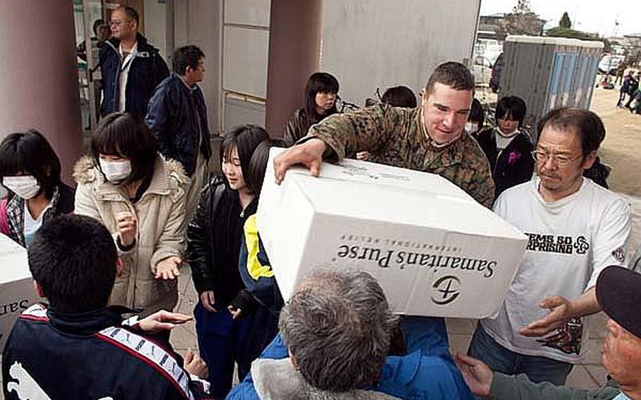 A unit of Marines and soldiers brought aid to a disaster shelter in Watari city March 25. Along with toys, the troops brought toothbrushes, soap and toilet paper.