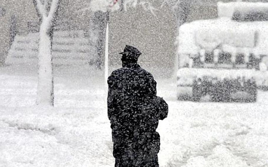 Two U.S. sailors walk through heavy snows on Misawa Air Base, Japan, early Saturday morning.