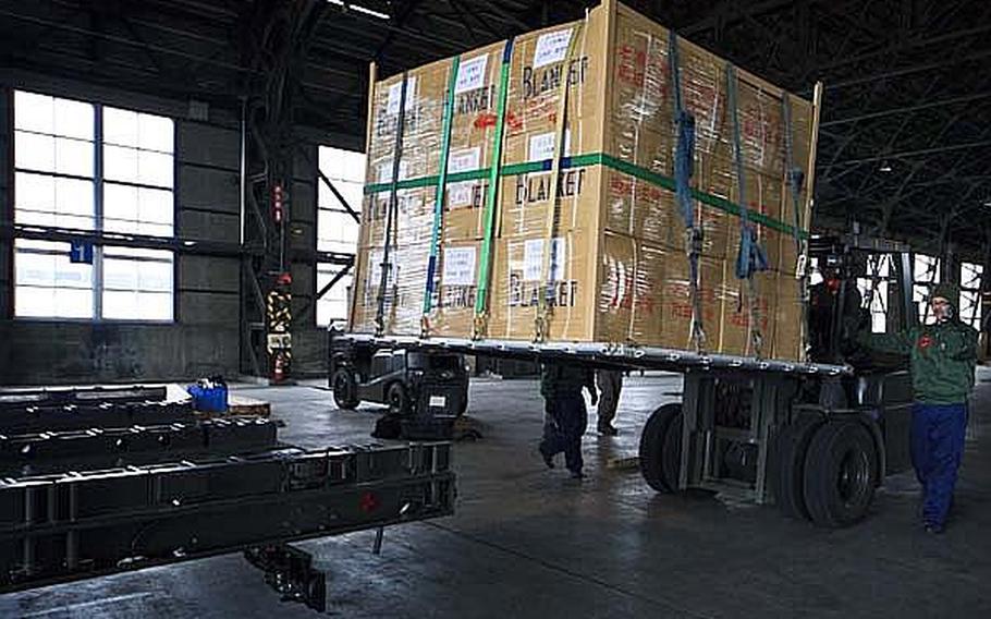 Japanese Air Self Defense Force personnel at Chitose Air Base help load pallets of food and supplies onto C-130's from Yokota Air Base headed to Matsushima Air Base, Wednesday. The supplies came from Yokota Air Base, which has become a hub of activity since the March 11 quake.
 
