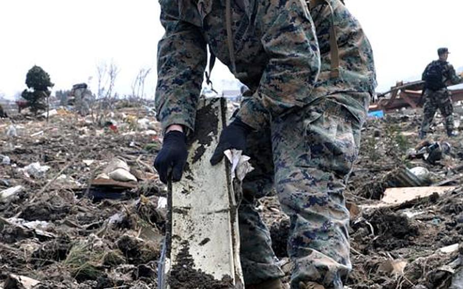 Lance Cpl. Garrett Williams pulls a strip of metal out of a massive debris field formed after a tsunami ripped through Noda Village, in Iwate prefecture, Japan, on March 11. The 20-year-old Marine and father of a 7-month-old said pulling kids' toys from the destroyed neighborhood was especially tough.