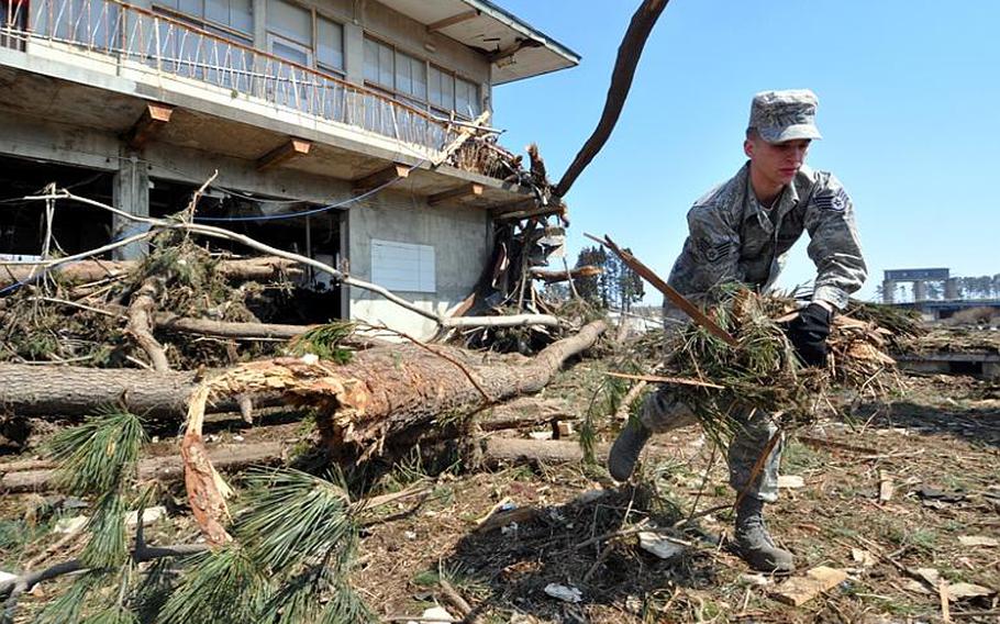 Air Force Staff Sgt. Samuel Clem, with the 35th Communications Squadron at Misawa Air Base, Japan, cleans debris from Noda Village on Friday.