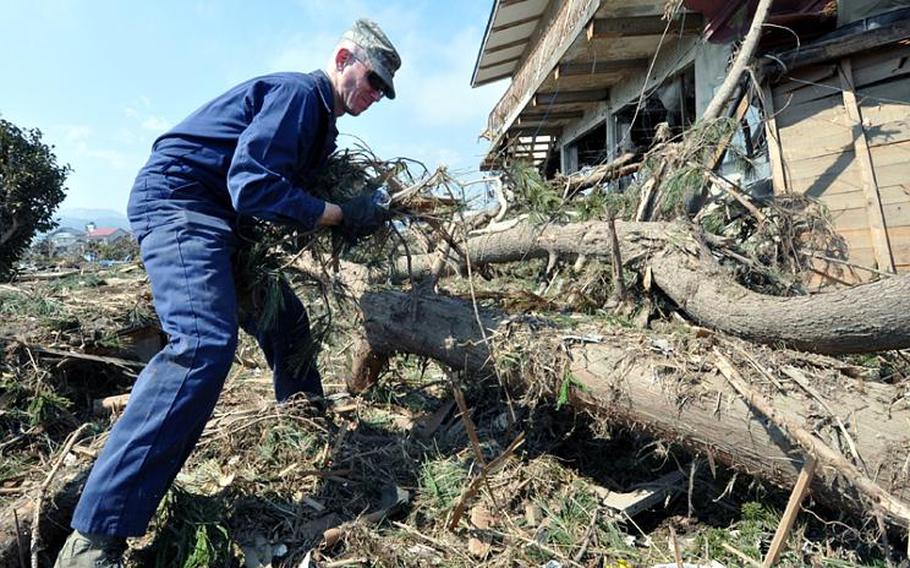 Air Force Master Sgt. Chris Burch pulls debris out of an area of Noda Village on Friday. Burch and Capt. Tyler Harris are in charge of volunteer clean-up trips from Misawa Air Base into surrounding Japanese communities.