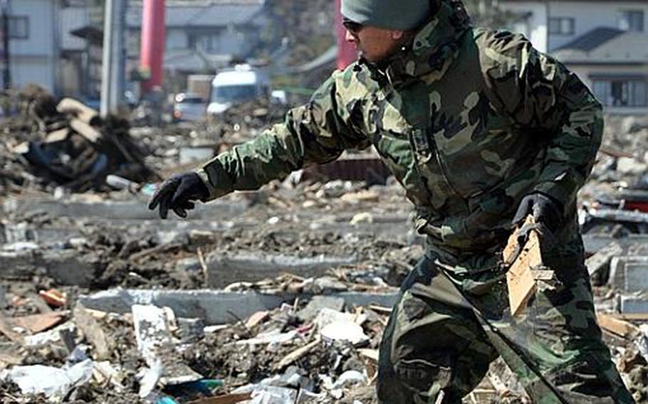 Tech. Sgt. Luis Cantu helps remove debris Friday from a destroyed neighborhood in Noda Village, about a two-hour drive south of Misawa Air Base. The fishing village was ravaged by a March 11 earthquake and tsunami.