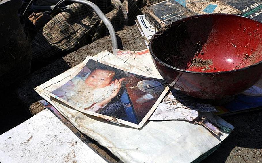 Small piles of valuables -- things such as pictures or written documents -- were dotted across a work site Friday at Noda village as volunteers cleaned a tsunami-stricken neighborhood.