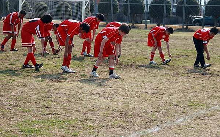 The boys soccer team from Nile C. Kinnick prepare for their match by doing some group stretches during Sports Day on this Saturday at Bonk Field, Yokota Air Base, Japan.  The young athletes came from schools throughout the Kanto region to participate in the sports day. The regularly scheduled sporting events for Defense Department schools' athletes in the Kanto Plain were canceled following the March 11 earthquake, leading officials to come up with the sports day as a way for the athletes to take part in some competition.