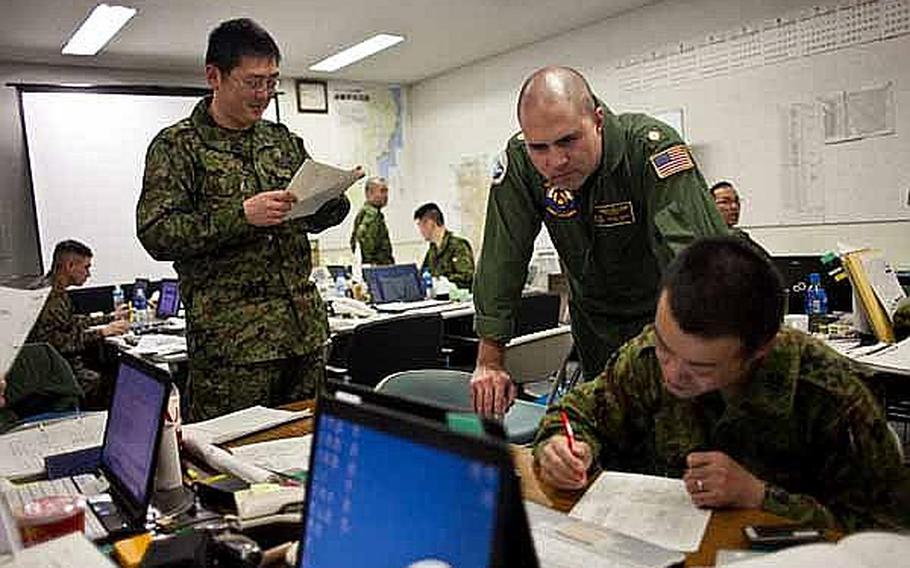 Lt. Cmdr. Barnet Harris, assigned to the Bilateral Crisis Action Team at Camp Sendai, Japan, works with Japan Self-Defense Force troops to coordinate U.S. and Japanese relief efforts.